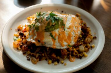 a white plate topped with an egg covered in toppings