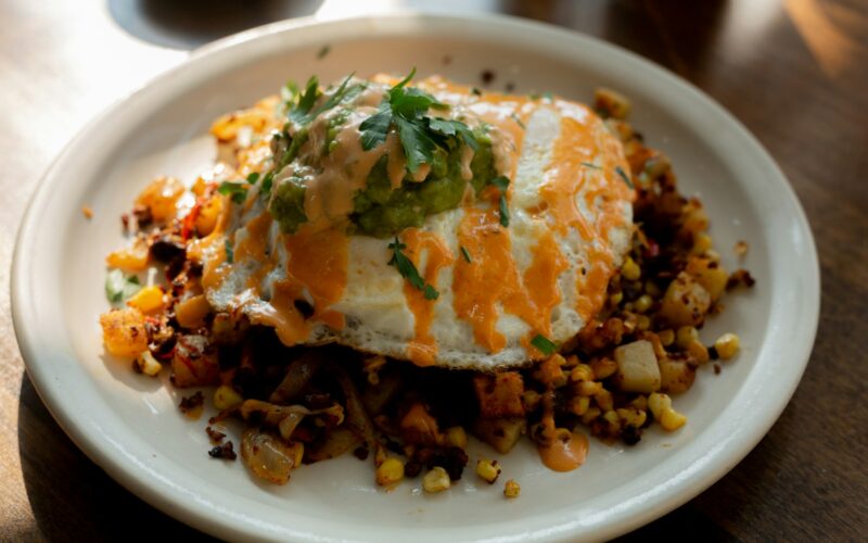 a white plate topped with an egg covered in toppings