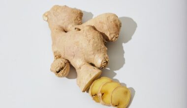 a ginger root and a piece of ginger on a white surface