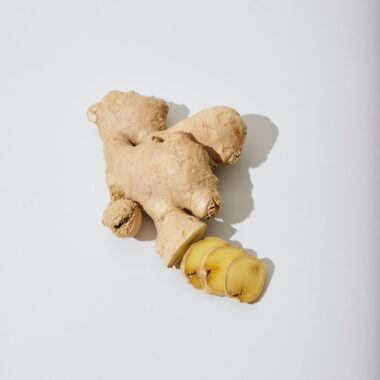 a ginger root and a piece of ginger on a white surface