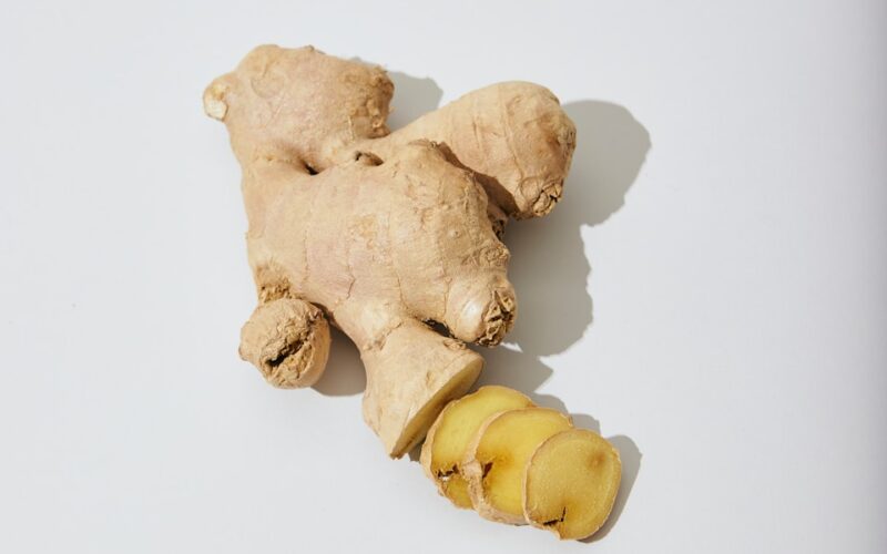 a ginger root and a piece of ginger on a white surface